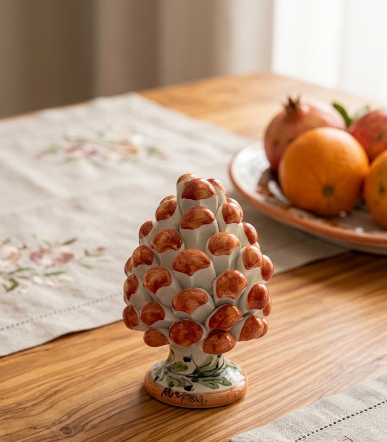 Pigna in ceramica siciliana arancio su tavolo in legno, decorazione casa