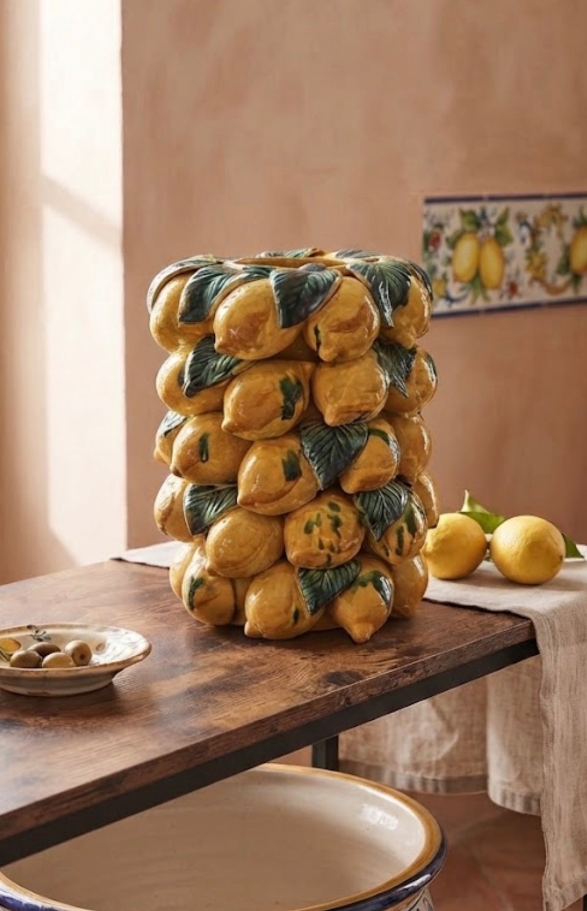 Vaso Limoni in ceramica con frutti gialli e foglie verdi in rilievo, ambientato su un tavolo