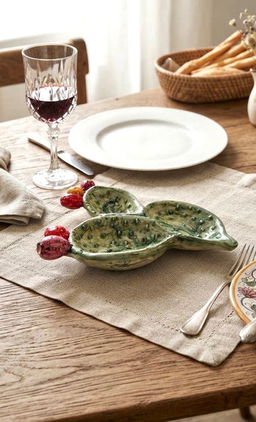 Antipastiera Fichi d'India in ceramica verde con frutti colorati su una tavola apparecchiata