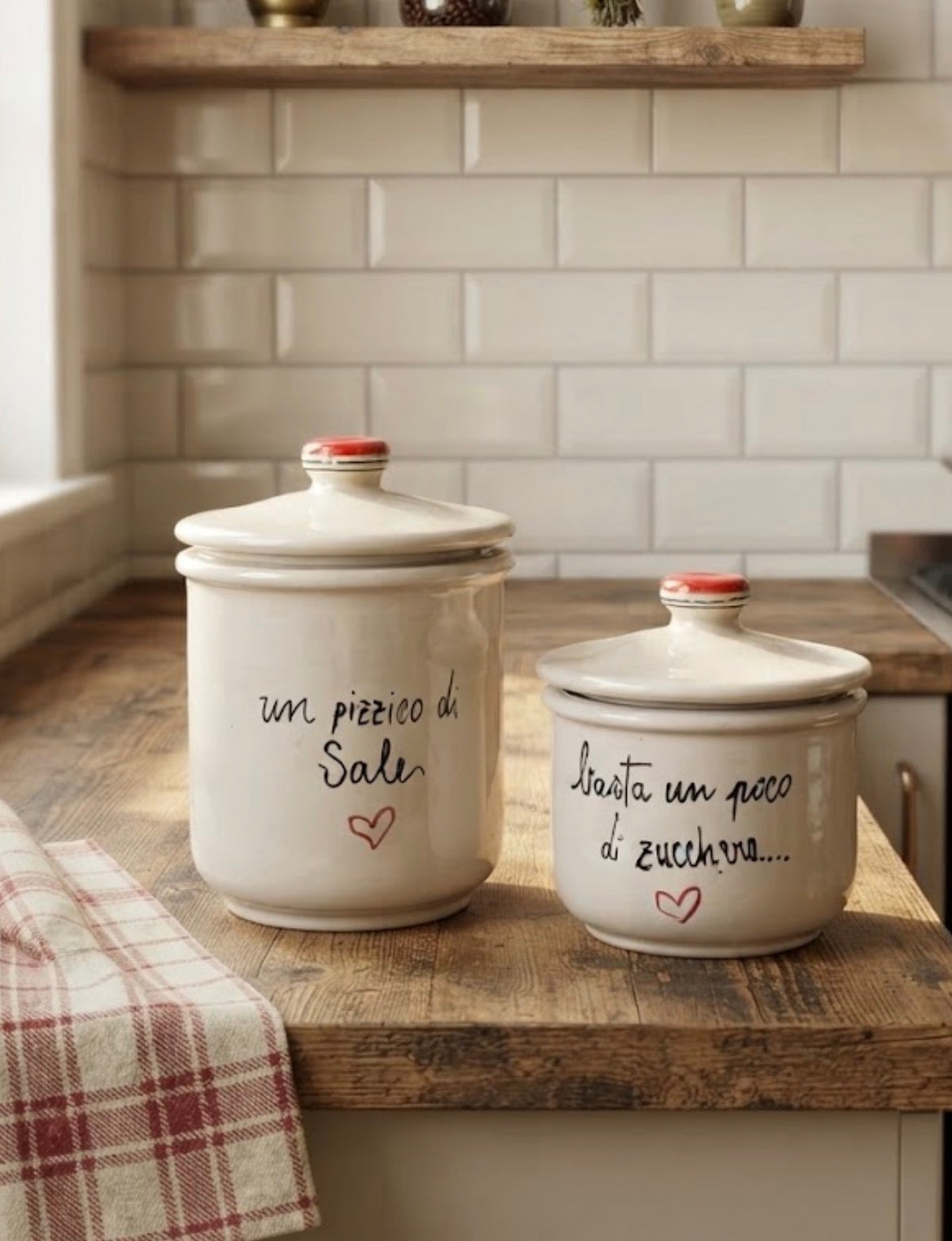 Barattoli sale e zucchero in ceramica bianca con cuori rossi, ambientati su un piano cucina in legno
