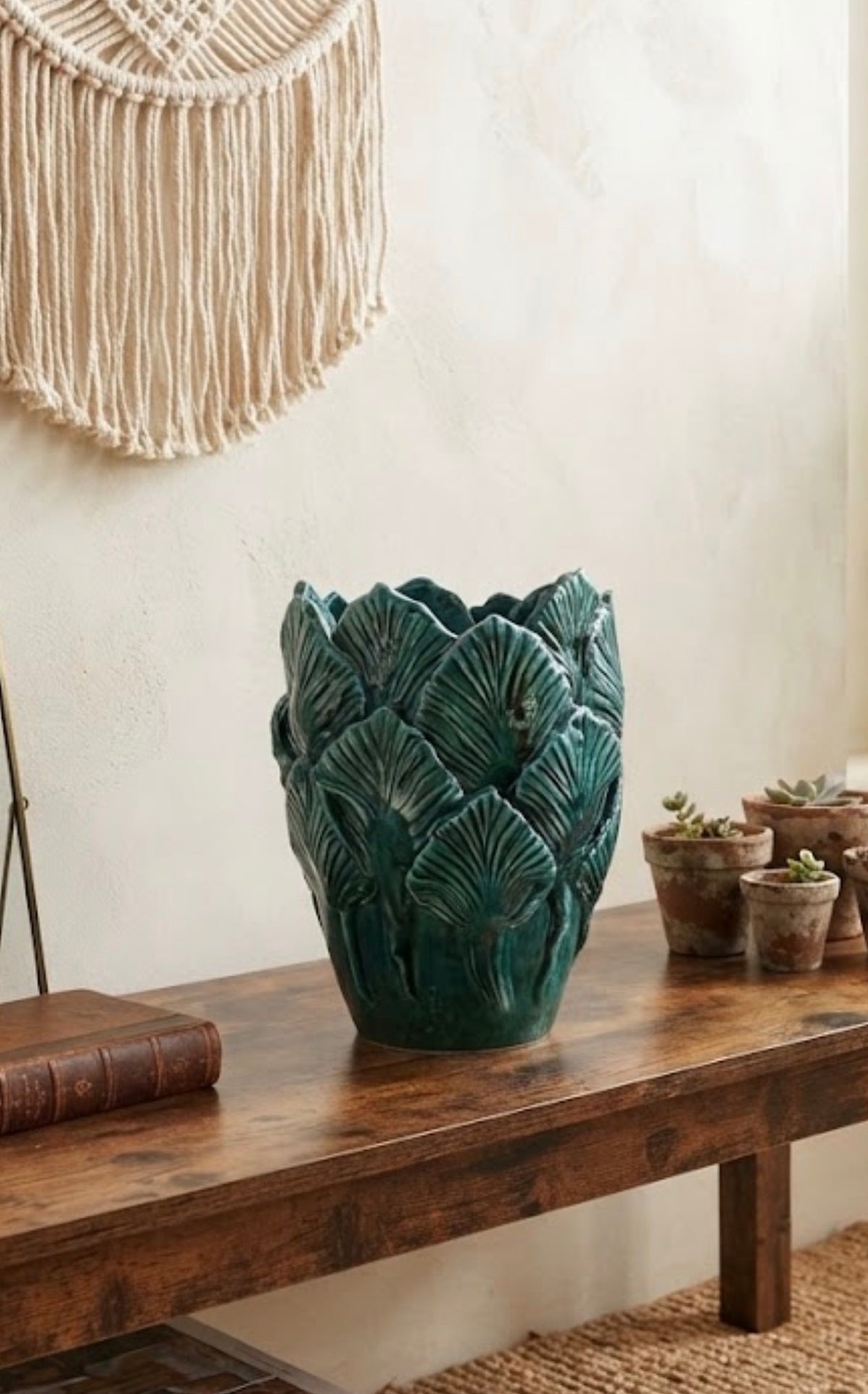Vaso Bali Collection verde ramina con foglie in rilievo, ambientato su una consolle in legno