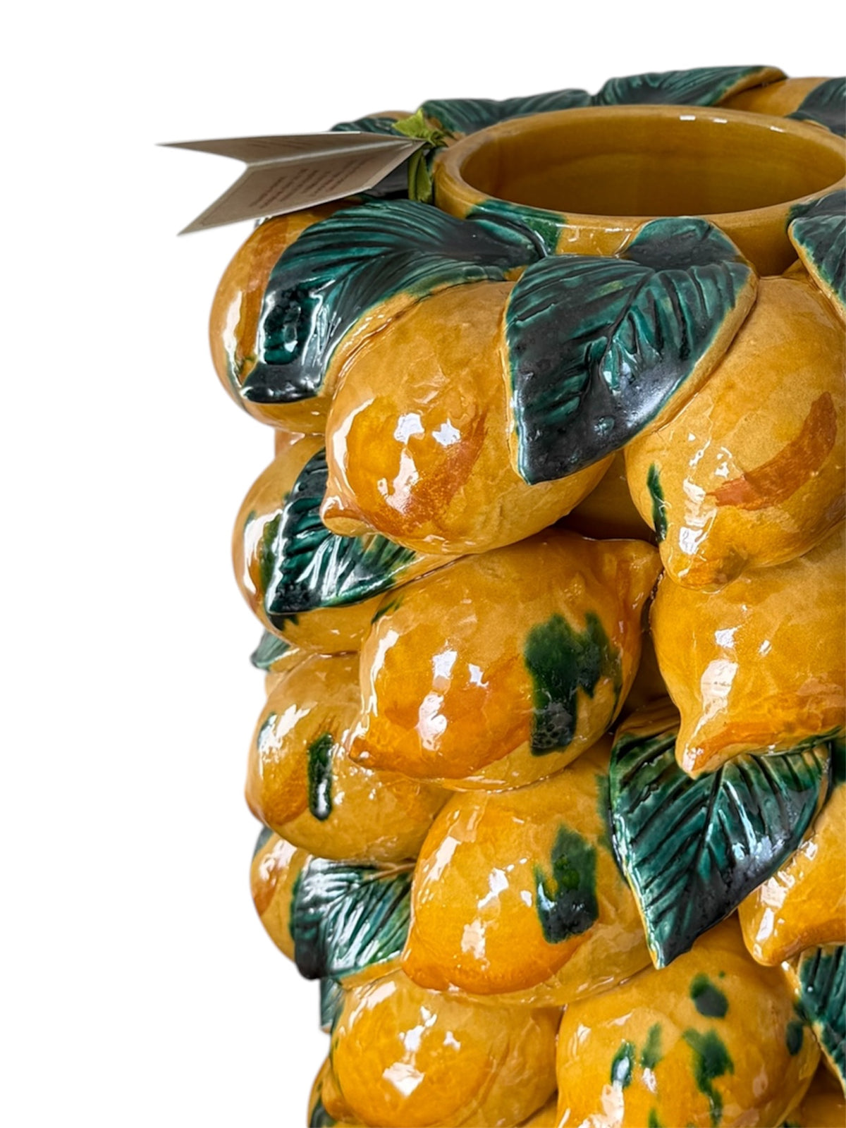 Dettaglio del bordo e dei limoni gialli con foglie verdi sul vaso in ceramica