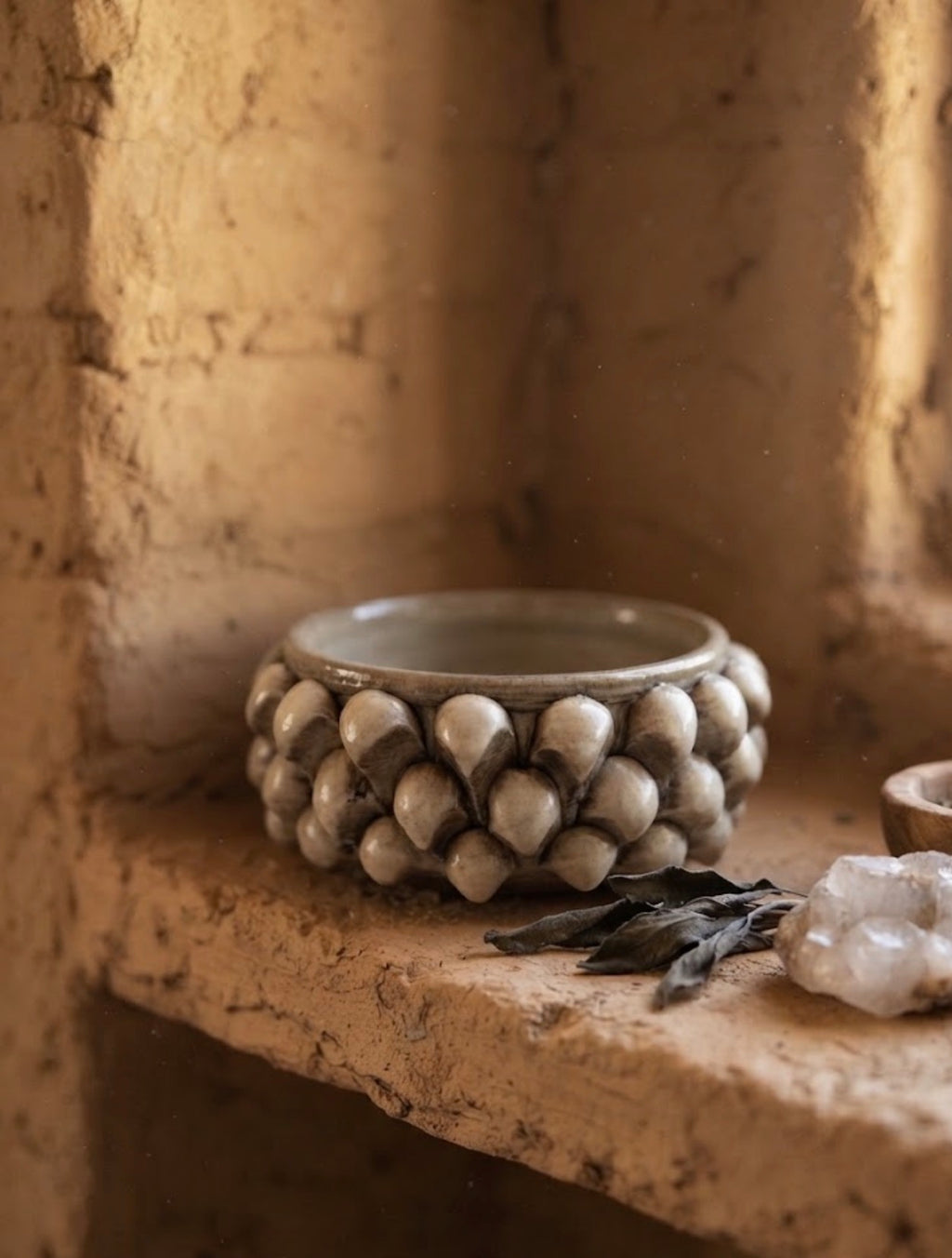 Svuotatasche Pigna in ceramica tortora pennellato, ambientato su una mensola in pietra