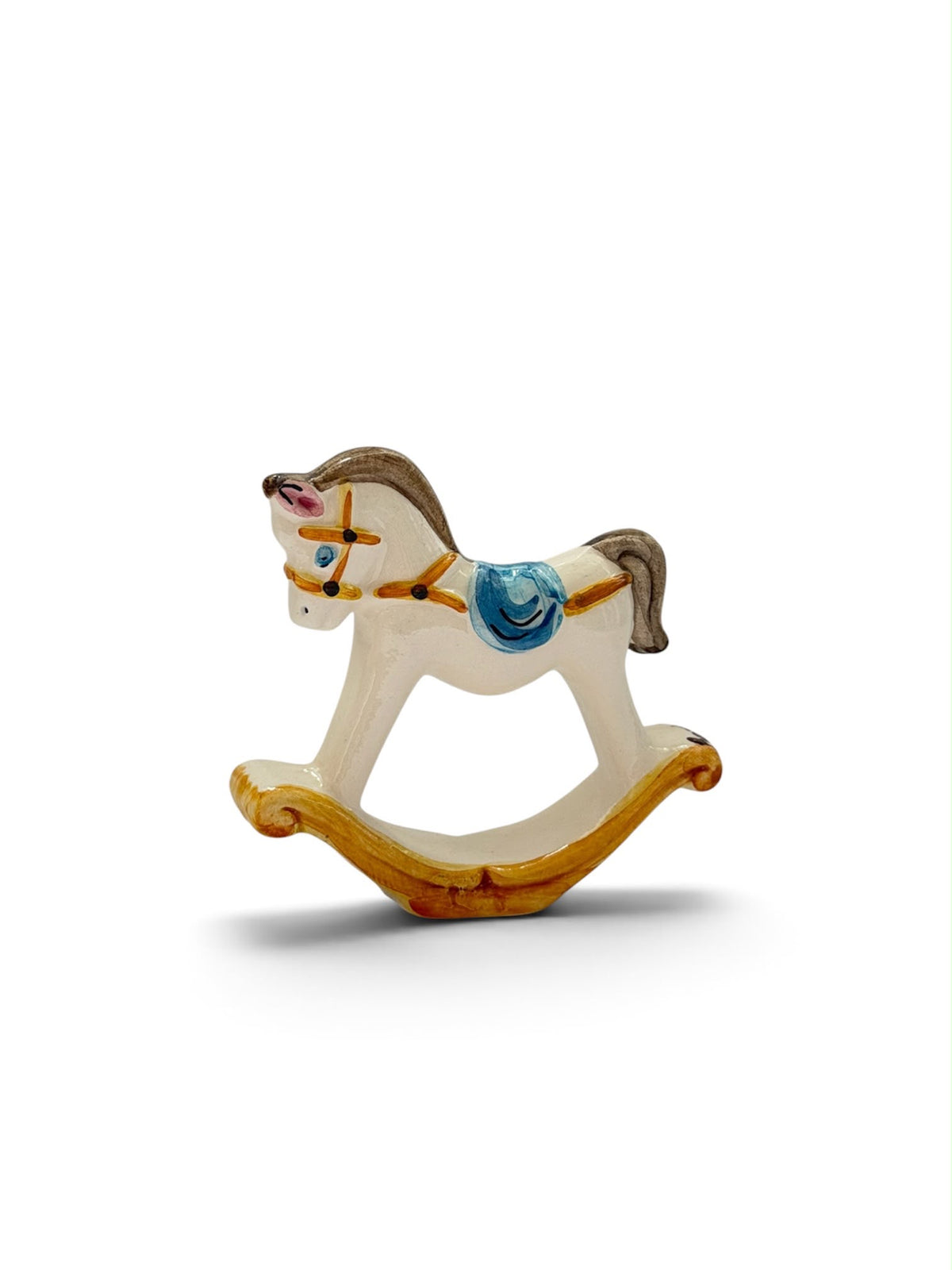 Cavalluccio a dondolo in ceramica bianco e blu, figura intera su fondo bianco